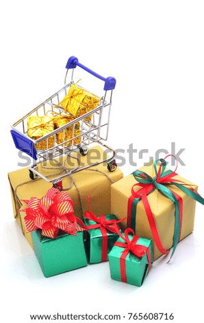 Shopping cart with green and brown gift box and red ribbon isolated on white background.