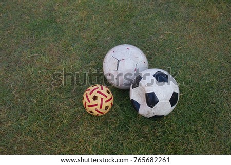 dirty soccer football and sepak takraw on green grass field