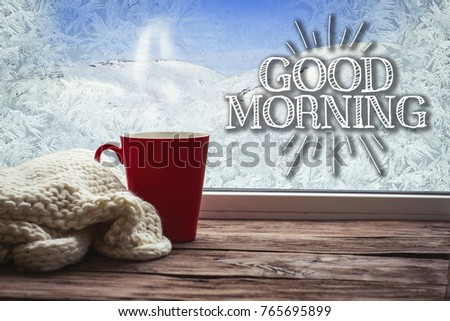 A beautiful image of a red cup on a window sill with a beautiful winter landscape outside the window.