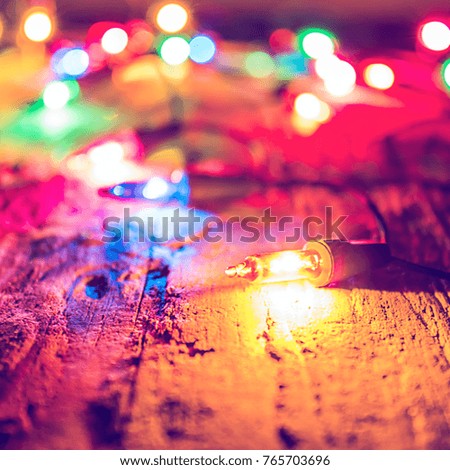 Christmas blurred colorful lights on dark wooden background. Decorative bokeh lights, garland.