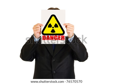 Concept-radiation hazard!  Businessman holding radiation sign in front of face