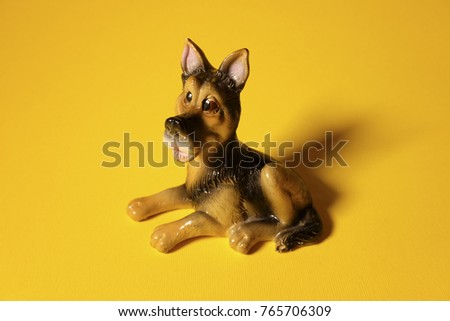 a dog statue, a dog on a yellow background, a puppy, a dog year