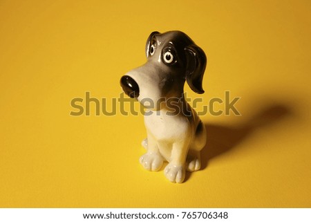 a dog statue, a dog on a yellow background, a puppy, a dog year