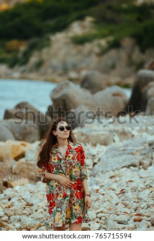 Caucasian girl relaxing and enjoying peace on vacation. Young brunette woman in summer days at sea. Woman with sunglasses.