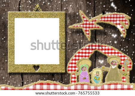 Christmas photo frame greetings card. Cute  Nativity Scene made with cheerful cuts of fabrics and golden glitter and empty picture frame hangin on rustic wooden wall.