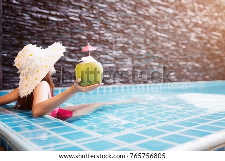 Young asian woman relaxing in swimming pool at spa resort.relaxing and spa relax concept.