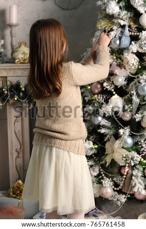 Beautiful little girl over Christmas tree on Holiday theme