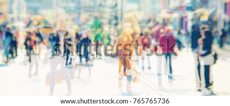 Crowd of anonymous people walking on busy city street