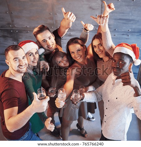 New Year is coming! Group of cheerful young multiethnic people in Santa hats on the party, posing emotional lifestyle people concept.