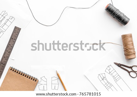 Tailor's work desk. Pattern of clothing and tools on white background top view copyspace Royalty-Free Stock Photo #765781015