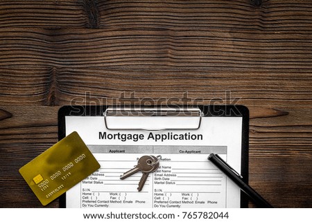Mortgage application near bank card and apartment keys on dark wooden background top view copyspace