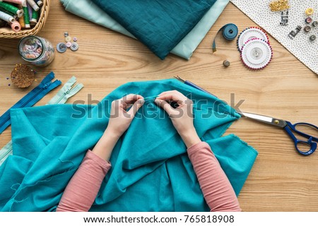 top view of cropped female hands sewing fabric with needle at seamstress workplace Royalty-Free Stock Photo #765818908