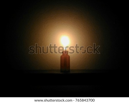 Blur picture of little candle in bottle in dark room
