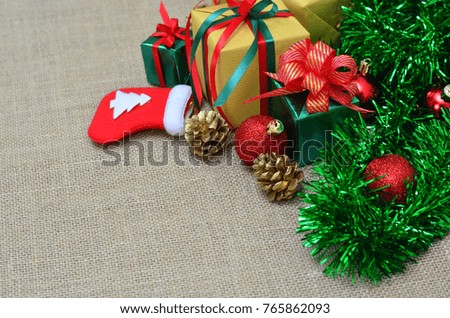 Flat lay of Christmas decoration. Christmas gifts, christmas tree, decorations on sack cloth background. Top view and copy space.
