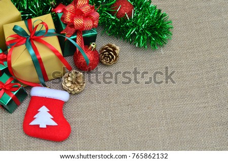 Flat lay of Christmas decoration. Christmas gifts, christmas tree, decorations on sack cloth background. Top view and copy space.