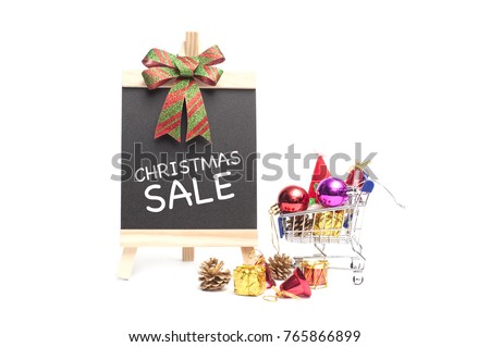 CHRISMAS SALE Concept.Chalkboard with text CHRISTMAS SALE and a mini shopping cart full of christmas toys and gift isolated over white background.Copy Space.
