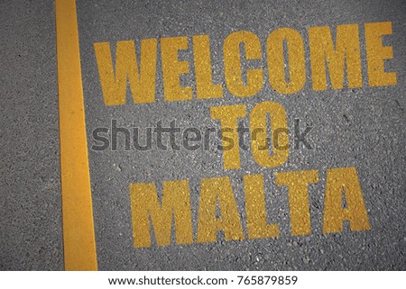 asphalt road with text welcome to malta near yellow line. concept