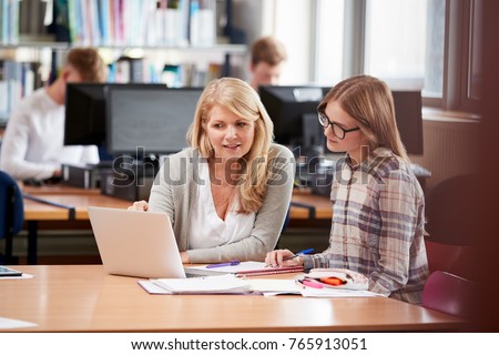 College Student Has Individual Tuition From Teacher In Library Royalty-Free Stock Photo #765913051