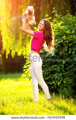 Beautiful girl is walking with a dog in the park