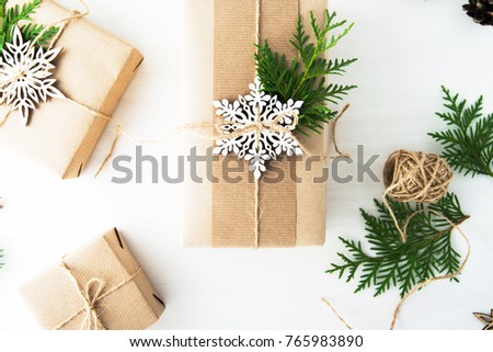 Christmas handmade gift boxes decorated with craft paper and white snowflakes on white wooden background top view. Merry christmas greeting card. Winter xmas holiday theme. Happy New Year. Flat lay.