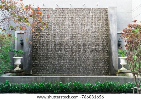 Waterfall on Stone wall in European garden
