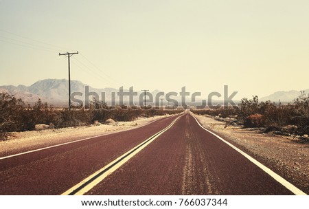 Retro old filmy stylized picture of an empty road, USA.