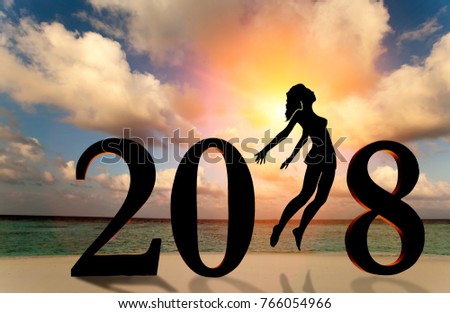 Happy new year card 2018. Silhouette of young woman on the beach stand as a part of the Number 2018 sign with sunset background.