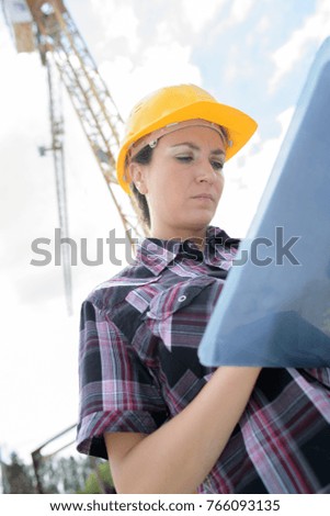 female contractor at a work site using an ipadtablet