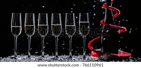 Champagne glasses set on black background with snow
