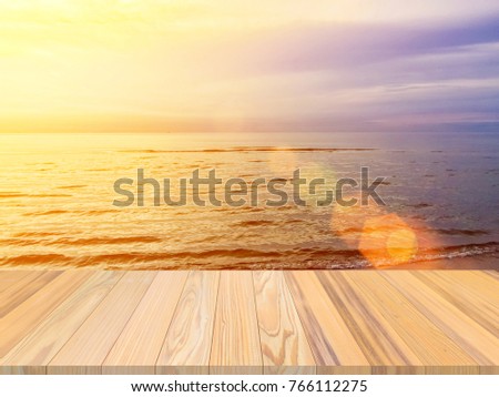 Wood terrace withe the blurred beach natural background blur warm colors and bright sun light summer background. Beautiful Landscape Ocean Summer sunset Natural background.
