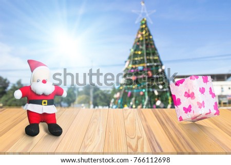 Wood terrace withe the blurred concept and beautiful decorated christmas tree with present gift box from santa in landscape with snow. Christmas concept.