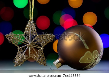 Christmas baubles in a box against a background of Christmas lights. Christmas dinner wrapped in cardboard box on the background of the lamps. Black background