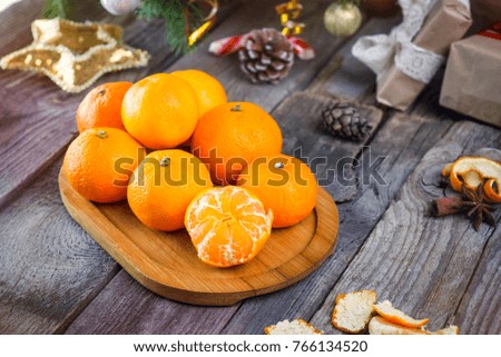 Christmas concept with Tangerines, Fir branches with decor , gifts and spices on the old rustic wooden table. New year background. Selective focus. Vintage toning. Space for text