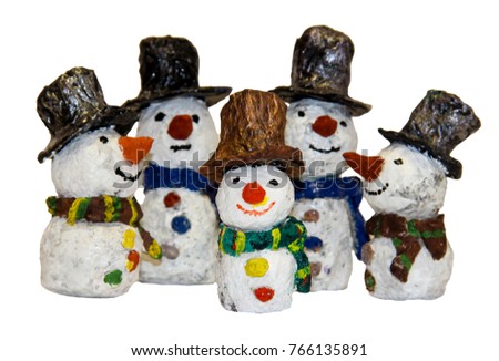 funny kids snowmen fashioned from papier-mache isolated on white, blurred image; covered with varnish shines in the sun