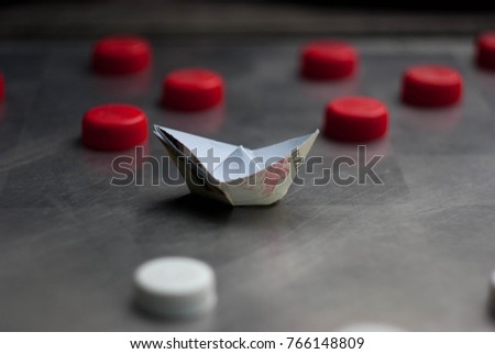 paper boat on chess board with checkers
