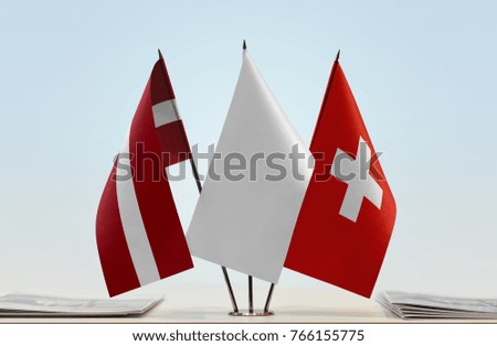 Flags of Latvia and Switzerland with a white flag in the middle