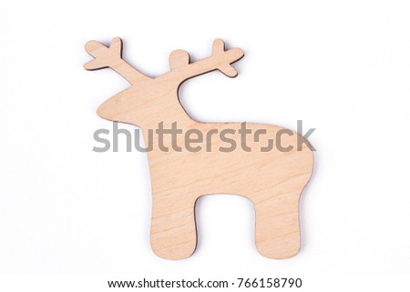 Cut out wooden figure of deer, white background. Carved wooden silhouette of Christmas decoration deer isolated on white background. Handmade New Year craft.