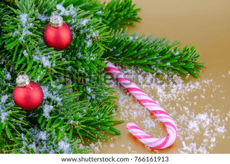 Christmas composition with red Christmas balls and fir branches on golden background.