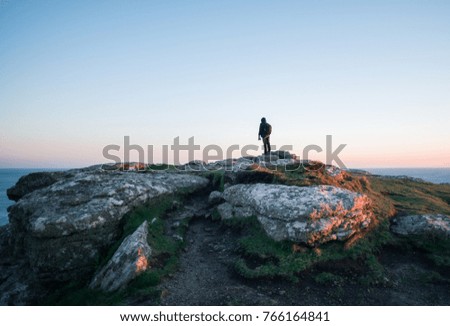 Man standing on rocks seascape at sunset