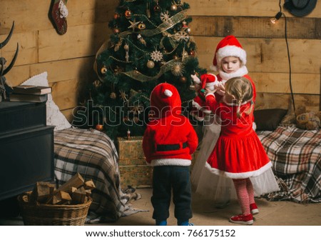 New year small girl and boy, happiness. Winter holiday and vacation. Christmas happy children in red hat. Santa claus kid at Christmas tree. Xmas party celebration, childhood