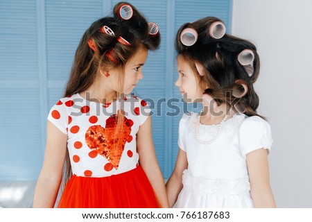 Close-up picture of cute little girls with hair curlers 