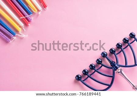 Image of jewish holiday Hanukkah  colorful candles, menorah (traditional Candelabra) on pink background.Flat lay.Copy space for text.