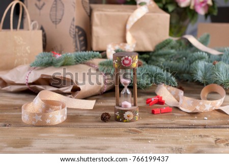 hourglass on a wooden background and gifts and roses
