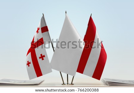 Flags of Georgia and Austria with a white flag in the middle