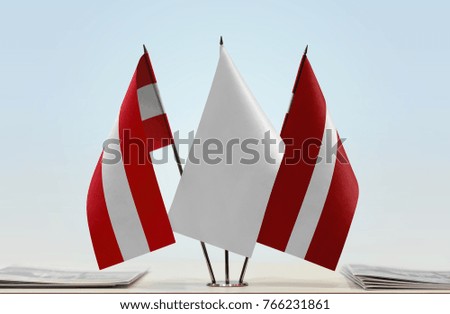 Flags of Austria and Latvia with a white flag in the middle