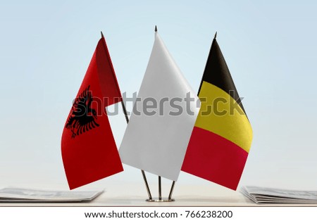 Flags of Albania and Belgium with a white flag in the middle