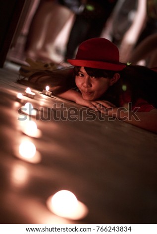 Worldwide candle lighting day concept: A girl with blurred candle light on christmas night background