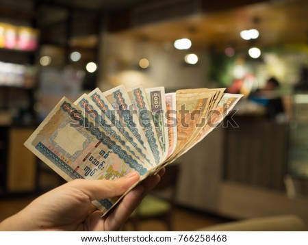 closeup hand man holding money of myanmar kyat burma with blur background Royalty-Free Stock Photo #766258468