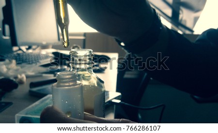 a scientist droping yellow liquid into speciment bottle to do experiment.