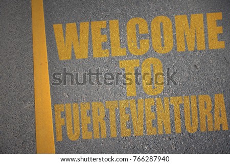 asphalt road with text welcome to fuerteventura near yellow line. concept